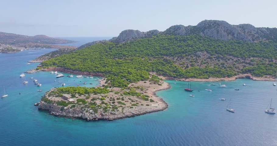 Ascending drone shot of moored yachts and catamarans on a beautiful bay for diving