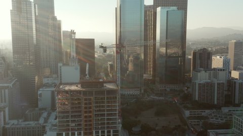 AERIAL: Flying towards Construction Site Skyscraper in Downtown Los Angeles, California Skyline at beautiful blue sky and sunny day 