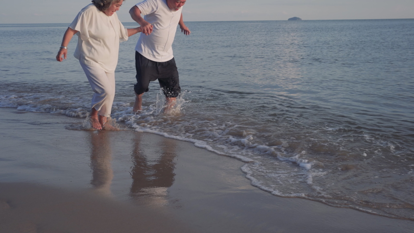 Happiness Asian couple senior elderly retirement resting and running at sunset beach honeymoon family together people lifestyle, Slow motion footage Royalty-Free Stock Footage #1062860875