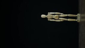 Vertical video Stopmotion wooden figure dummy in studion on black background