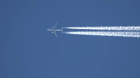 Jet airliner flying high in the sky leaving contrails in the clear blue sky