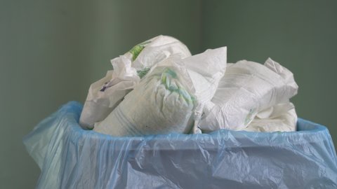 Dirty baby diapers in the trash. Disposing of used nappies. The problem of environmental pollution with disposable plastic products