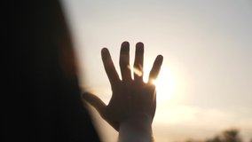 Silhouette of a happy dreaming girl pulls her hand to the sun. Religion helping hand. Happy girl pulls her hand. Prayer in religion. Silhouette of a hand in the sun. Happy girl silhouette at sunset - Powered by Shutterstock - Get 15% off with code: PIKWIZARD15