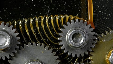 Super Slow Motion Shot of Gear Mechanism and Oil on Dark Background at 1000 fps.
