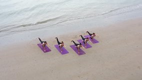 B roll Aerial view drone shot Athletic group of women practicing yoga position at sunrise beach. Fitness training outdoor stretching body at morning. Morning yoga practice soft sunlight on the beach. - Powered by Shutterstock - Get 15% off with code: PIKWIZARD15
