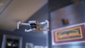 Mini drone weighing 249 grams close-up against a blurred background at home, the drone camera shoots in 4K.