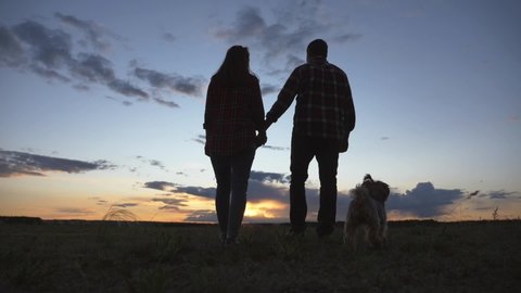 Silhouette of happy family and dog. Happy family run to park at sunset. Teamwork is path to success. Family teamwork concept. Helping hand for business success. Silhouette of run young couple and dog
