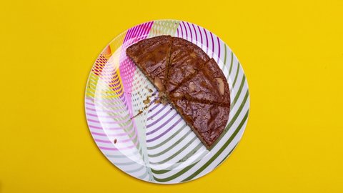 TOP VIEW: Eating a layer of banana cake on yellow background – 4k Stop motion.