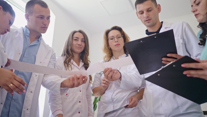 Female Doctor and Young Medical Interns in Medical Clothing Studying Together the Results Chest X-Ray Scan of Patient. Middle-Aged Woman Therapist Teaching Young Interns How to Analyze X-Ray Image | Shutterstock HD Video #1062881866