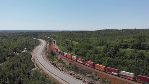 Aerial view of a massive train passing by the forest in northern Canada