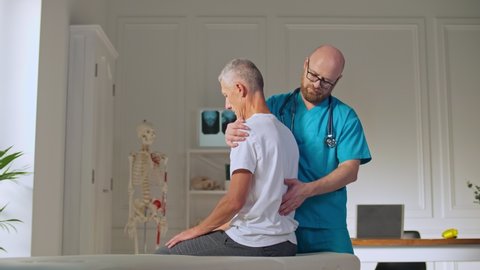 Physiotherapist Conducting a Therapy Session With an Older Man in a Rehabilitation Center. Sports Physiotherapy Concept