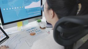 Over head shoulder back view of young attractive asian woman busy work multiple screen computer and smart tablet on table desk at home in concept freelance data analyst, data scientist for business. - Powered by Shutterstock - Get 15% off with code: PIKWIZARD15