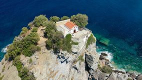 Aerial drone video of picturesque chapel of Saint John built in rocky seaside cliff, Skopelos island, Sporades, Greece