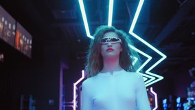 Fashion young woman in futuristic glasses and white costume walks in night club in city of future. Blue and violet neon lights. Trendy stylish millennial female. VR club, future technology. Following - Powered by Shutterstock - Get 15% off with code: PIKWIZARD15