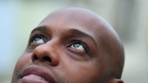 African mixed race man looking up to sky. Close-up in contemplation