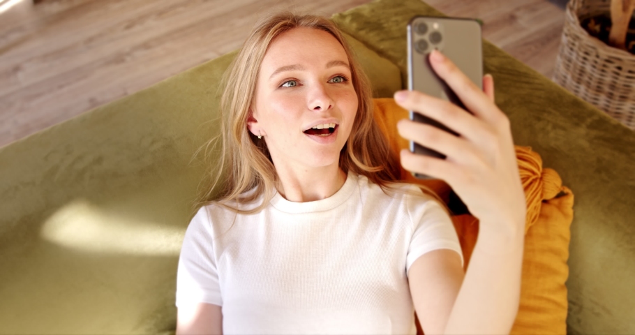 Young woman making video call chat online on mobile phone at home. Talking over video call conference  recording vlog. Remote communication at a distance. Royalty-Free Stock Footage #1062895693