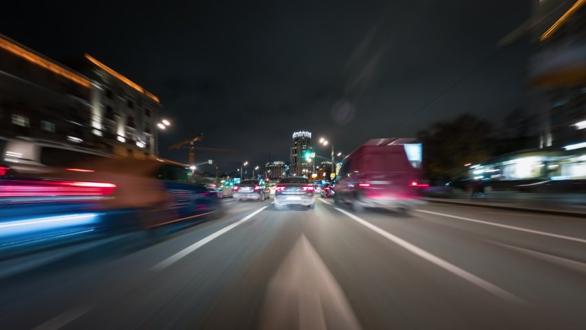 Amazing motion timelapse of the night rush drive in a big city. Speedy car driving the highway with a lot of lights and traffic, overtaking other vehicles and passing by skyscrapers along the road. Royalty-Free Stock Footage #1062895912