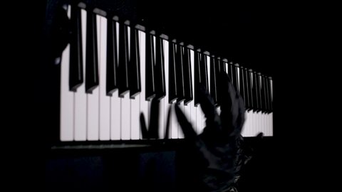 the hands of a pianist in black medical gloves play the piano. concept of performance during a pandemic. learning to play the piano.