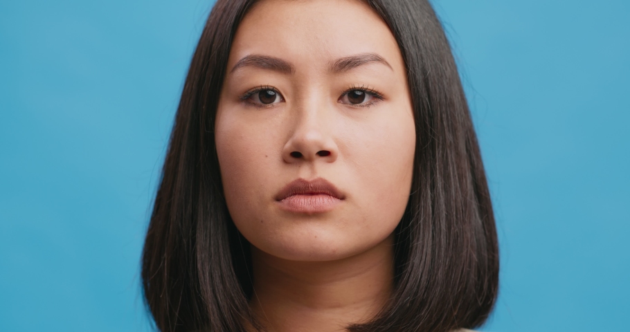 Close up portrait of shocked amazed asian woman touching face in astonishment and wonder, blue studio background Royalty-Free Stock Footage #1062897559