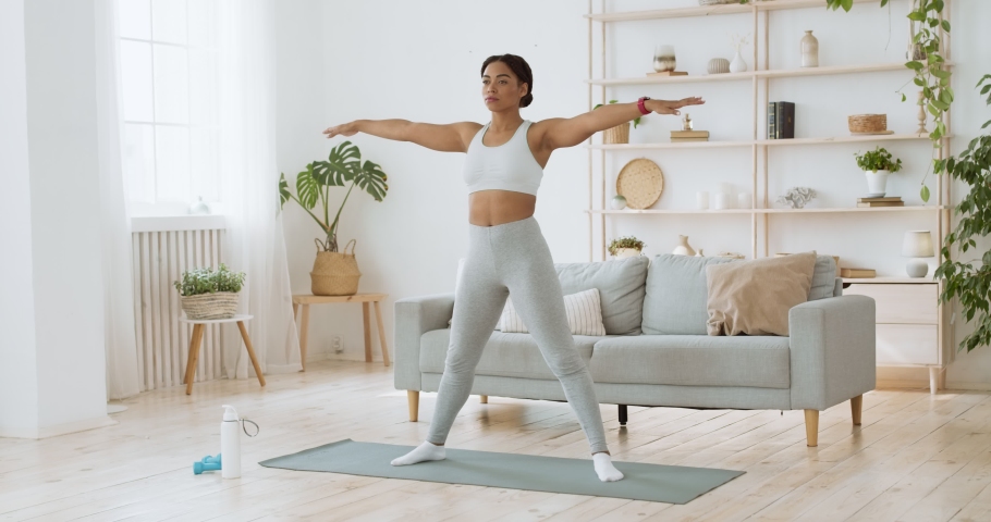 Body stretching exercise. Young yogi black lady tilting her body to sides at home, slow motion Royalty-Free Stock Footage #1062897814
