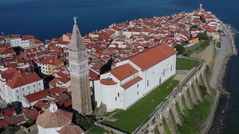 Drone shot of Church of Saint George standing on a hill in coastal town Piran, Slovenia.