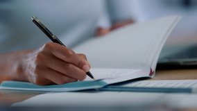 Closeup mixed race businesswoman hands making notes in notebook at workplace. Unknown female entrepreneur writing schedule in diary book. Business woman arms crossing text in notebook - Powered by Shutterstock - Get 15% off with code: PIKWIZARD15