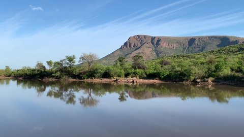 Tlopi Dam scenic view of sandstone mountains and egyptian geese flying in Marakele National Park, Limpopo Province, South Africa