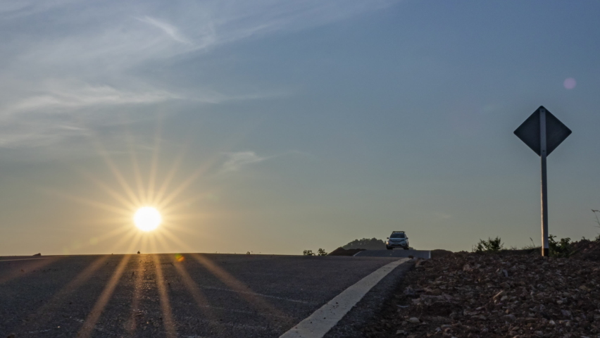 Beautiful Dramatic Fast Lapse Time of Sunset and Clouds in the Blue Orange Sky. The Sun Sets Over the road.