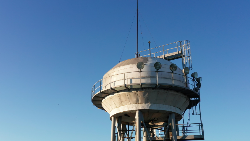 Water tower - elevated liquid storage tank. Metal reservoir for compressed gases or hazardous chemicals in a factory or industry plant. Drone aerial view.