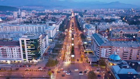 Street lights of downtown Podgorica Montenegro at night. Illuminated main street in the evening. Traffic on the avenue passing through commercial and residential city center. Drone aerial view.