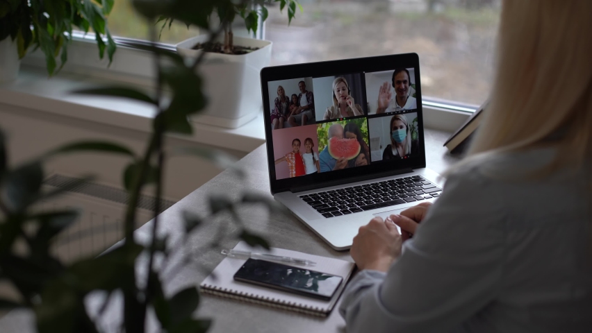 Online Group Video Call Conference of Work Team from Home Office. Woman in Headphones Talks with 4 People at Video Chat using Laptop. Self-isolation at COVID-19 Pandemic. 4K Top View Medium Orbit Shot Royalty-Free Stock Footage #1062919999