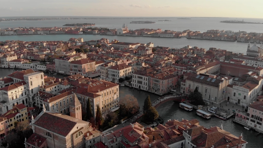 Aerial view of the busy bridge near Venice. A drone panorama of the city overlooking the canal of the Adriatic Sea in northern Italy. A shot of people walking across the bridge from a drone. Sunset