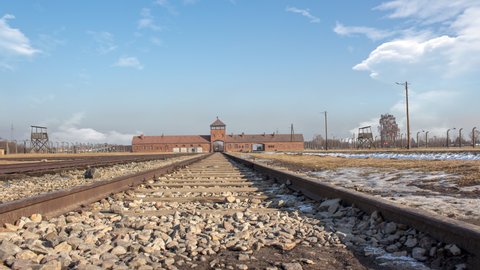 Time lapse of Auschwitz concentration camp in occupied Poland during World War II and the Holocaust. during a sunny cloudy day. There is the  train binary in close up