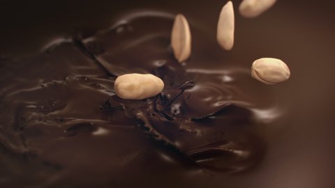 Peanuts Falling Into Liquid Chocolate in 4K Super slow motion
