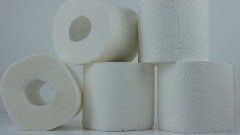multiple rolls of white toilet paper on a white table