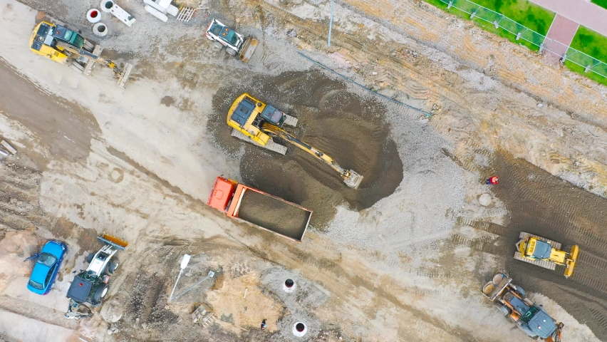 Construction of a city street, laying of communications, installation of sewer hatches, gutters, curbs. Preparation for paving, aerial view Royalty-Free Stock Footage #1062935680