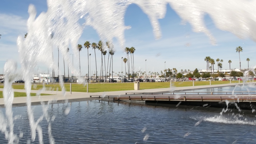 Fountain in waterfront city park near San Diego county civic center in downtown, California government authority, USA. Pacific ocean harbour, embarcadero in Gaslamp Quarter. Palms and grass near pier.