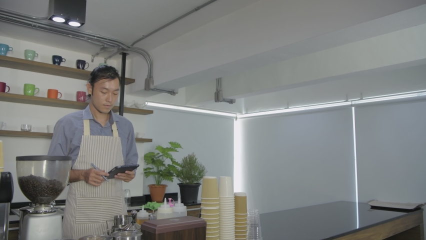 Coffee shop concept of 4k Resolution. Asian male employees are taking down customer orders.