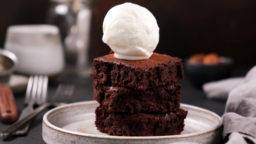 Chocolate brownies with vanilla ice cream and chocolate syrup. Syrup pouring on ice cream on brownies. Rich in sugar high calorie sweet food Royalty-Free Stock Footage #1062937669