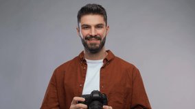 photography, profession and people and concept - video portrait of happy smiling man or photographer with digital camera over grey background