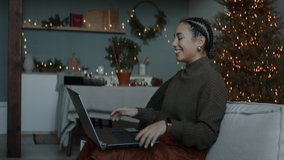 Mixed race female having a video call with friends or family on Christmas eve. Holidays celebration during COVID-19 Coronavirus isolation lockdown - Powered by Shutterstock - Get 15% off with code: PIKWIZARD15