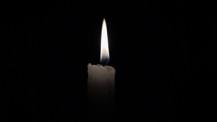 Candle. Match lights the candle wick. Light a candle in the darkness. Flame of a candle lit on a black background. Royalty-Free Stock Footage #1062939166