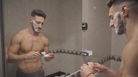 Video A young man begins to shave by hitting his beard