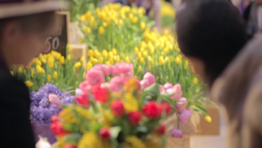 Shopping at the store. Customer buys a bouquet of flowers in a flower shop. Beautiful vibrant tulips. Springtime, celebration concept. | Shutterstock HD Video #1062939898