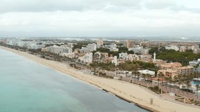 Aerial shot of beach and city during the Coronavirus pandemic. Drone video of the beach and promenade on which there are no people Mediterranean Sea with waves in Palma de Mallorca.