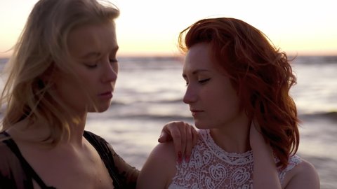 Sensual shot of two female lesbians looking at each other at sea