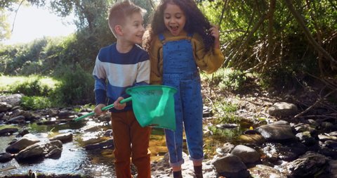 Small children catching fish in the river with net