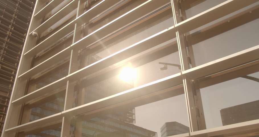 facade of an office building at sunset. the sun reflects off the windows of an office building Royalty-Free Stock Footage #1062951628