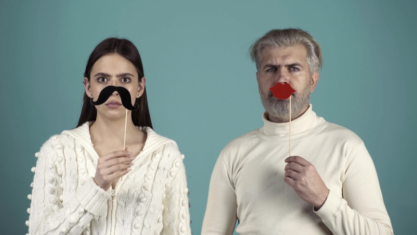 Funny couple change gender. Funny and Crazy Idea. Humorous video. Human emotions, youth, love and lifestyle. Stereotypical gender roles. Couple with paper mustache and female red lips Royalty-Free Stock Footage #1062954238