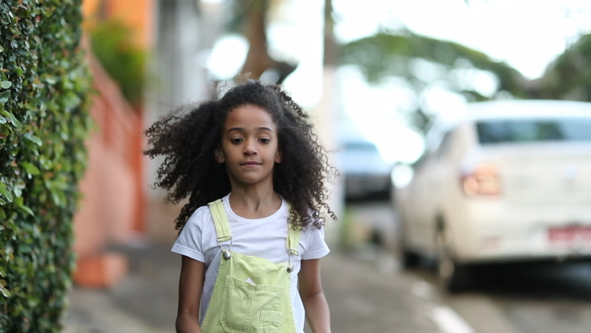 Happy little girl running outside in sidewalk. Mixed race black child feeling jow in slow-motion run | Shutterstock HD Video #1062955045